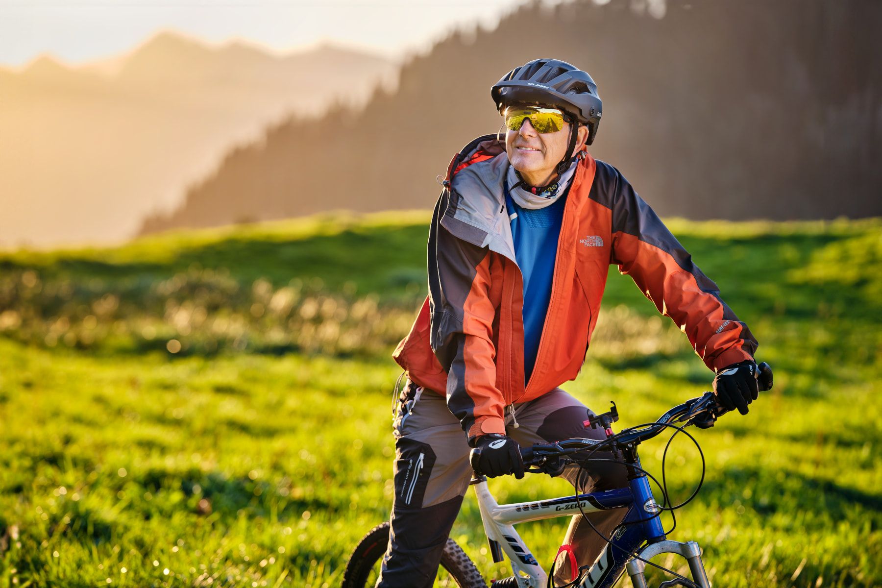 Sportbrillen – Ein Mann sitz bei schönstem Wetter auf seinem Fahrrad und geniesst die sportliche Aktivität in der Natur.